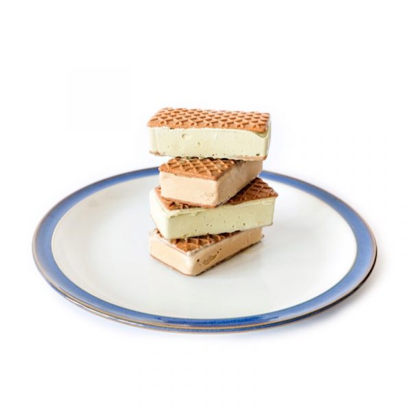 biscotti quadrati ripieni di gelato al pistacchio, disposti a piramide su un piatto